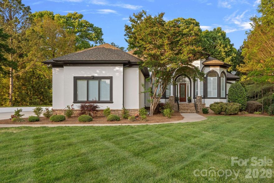 Situated on 1.3 acres in The Point’s prestigious Sturbridge Village, this two level waterfront estate offers views of Lake Norman and Trump National’s 13th fairway. Recently updated with NEW lighting, full interior and exterior paint, flooring and more, this home exudes refined elegance. Designed with five beautifully appointed bedroom spaces (permitted for four per septic) and over 6,300 SF of luxury finishes. Experience true open concept living as soon as you step inside. Custom curved floor to ceiling windows frame the exquisite views while vaulted ceilings on both levels give the home a light, airy feel. A true chef’s kitchen features NEW Cambria quartz countertops, NEW Thermador professional appliances, and NEW custom pantry with built-in wine cooler and bar cabinet. The main-level primary suite includes a spa-inspired bath, dual closets and private balcony access. Two additional bedrooms with ensuite baths and a private office are located on the main level. The lower lake level provides an opportunity for second living quarters with kitchen, theatre room, recreation area and two bedroom suites. Outdoor living shines with expansive covered terraces, outdoor kitchen, stone fire pit, private dock with deep-water access and room for a pool. Additional features include newly installed Trex outdoor staircase, a full home instant hot water system, oversized 3-car garage with plenty of guest parking, newer HVAC systems, and walk-in storage areas. Enjoy world-class amenities at Trump National Golf Club—golf, tennis, dining, fitness, social activities. NEW pickleball courts located right across the street.