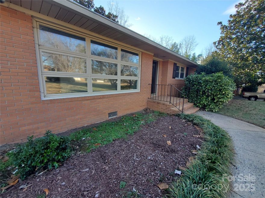 Welcome to your new Mid-Century brick ranch. Discover this charming Mid-Century brick ranch, nestled in a serene Shelby neighborhood and conveniently situated near Highway 74. Enjoy a spacious lot with a large rear deck, offering excellent opportunities for customization to meet your needs. This home features three bedrooms and two full bathrooms. The layout provides versatile gathering areas with options for privacy, highlighted by a spacious living room and an expansive Kitchen-Den-Breakfast area. One of the full baths includes a walk-in tub, which may appeal to specific buyers. A notable feature of this property is the whole home generator, a rarity in many residences. The furnace was replaced in 2021, and new flooring added in 2024. The seller acknowledges the need for some updates, so let’s begin that discussion. Great news for USDA loan seekers: this home qualifies for USDA loan options!