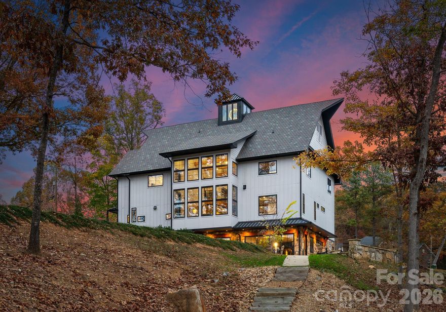 This exceptional waterfront residence is offered fully furnished, providing a seamless, move-in-ready opportunity for luxury lake living.

Designed for both impressive entertaining and everyday comfort, the home features elevator access to all levels, expansive lake views from multiple floors, floor-to-ceiling glass, Andersen windows and doors, white oak flooring, refined architectural detailing throughout, and a whole-home water filtration system.

The main living level showcases a dramatic great room with a custom fireplace, soaring ceilings with illuminated cupola, cedar-wrapped beams, and walls of glass framing panoramic Lake Norman views.

The chef’s kitchen is thoughtfully designed with custom cabinetry, quartzite countertops, a live-edge breakfast bar, Thermador Wi-Fi–enabled appliances, pot filler, beverage refrigeration, integrated lighting, and filtered water throughout the home.

The main-level owner’s suite offers a private lakeview retreat with fireplace, spa-inspired bath, and a striking walk-in shower, complemented by a beautifully designed custom walk-in closet.

Upstairs, additional guest suites and living spaces provide flexibility for hosting and multigenerational living, including a well-appointed bathroom with heated towel bar. The finished walk-out basement is ideal for elevated entertaining, featuring a full kitchen with Café appliance suite, full bath, and expansive living area that opens directly to the patio and waterfront through oversized sliding doors.

A rare amenity is the oversized, extra-deep garage accommodating 5+ vehicles and featuring a private golf simulator, offering a year-round recreational experience uncommon in waterfront homes.

Outdoor living is equally refined with a dock featuring a 32-foot slip and lighting, professionally landscaped grounds, shoreline stabilization, in-ground irrigation, and lake-fed irrigation. Canoes convey, completing the effortless lake lifestyle.

The home is currently listed on VRBO and other short-term rental platforms, offering a turn-key opportunity for buyers interested in pursuing this avenue. Buyer to verify all short-term rental regulations, permitting, and use requirements with the appropriate governing authorities.

A rare opportunity to own a fully furnished luxury waterfront home on Lake Norman, where architectural excellence, recreation, and lifestyle converge.