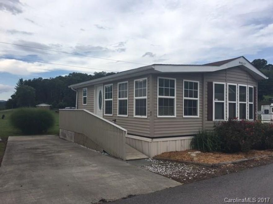 Park Model with mountain view.  1 bedroom 1 bath with open sitting/dining and kitchen.  Sunroom on front of home is included in HVAC.  Ramp entrance for easy access to the home.  Open deck