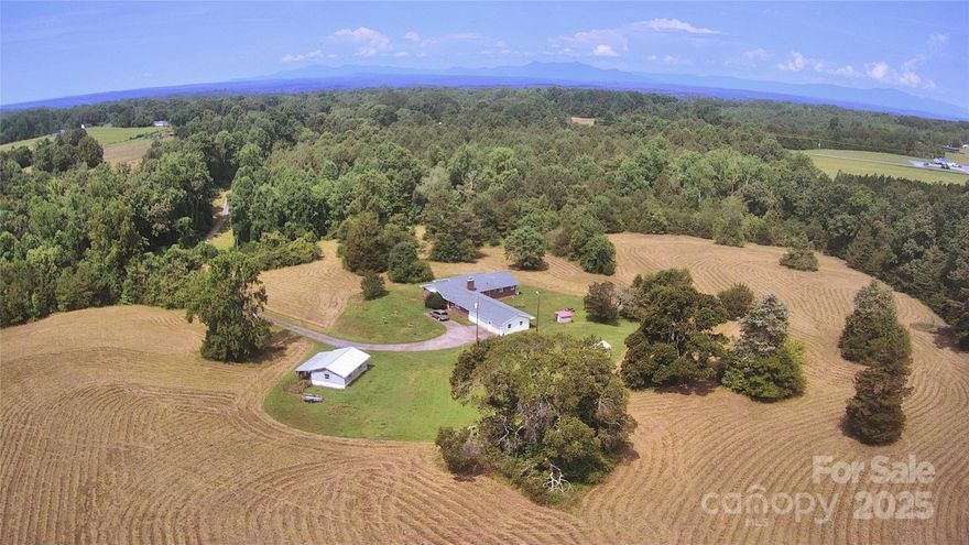 50 Acres of paradise, with 14 acres cleared+maintained, and beautiful hill-top farmhouse! Bring your contractor and your herd! This spot is an equestrian's ideal ranch, less than 20 min. to the Tryon International Center. Ride and stable on your own land, skip the boarding fees. High-speed cable internet inplace. Detached 30x20 shop has power from dedicated subpanel. City supply, stream frontage, and well provide three sources of water; Enough to keep homeowners, plants, and animals hydrated without bursting the water bill. Existing Farmhouse immaculately placed on the land, and would make an excellent foundation for a modern ranch home. Enjoy rural foothills solitude, 360 degrees of beautiful natural views, mature forest buffer on all sides, 1/3 mile of private driveway, and easy drive-times to all that Western North Carolina has to offer. If you love livestock, horses, hunting, hiking, or all of the above, you don't want to miss this uniquely well-laid-out parcel! House sold as-is.