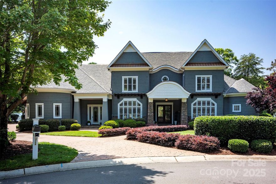 Impeccable craftsmanship and 305’ of pristine shoreline define this custom-built Lakeland Luxury waterfront home in The Point near Trump National Golf Club Charlotte. Enjoy panoramic Lake Norman views and resort-style living with a saltwater pool, spa, covered terrace with gas-log fireplace, outdoor kitchen, and private dock with boat/PWC lifts. Inside, reclaimed pine floors, exposed beams, stone/wood columns, and lake views from almost every room sets the tone. The chef’s kitchen boasts dual full-size paneled fridges, Monogram gas range with grill & griddle, 3 ovens, double islands, and adjacent breakfast room. The main-level primary suite offers lake views, terrace access, gas-log fireplace, luxurious bath, and dual walk-in closets. Entertain in the well-equipped media room, billiard room, and bar areas. Library/loft, 4 more ensuite bedrooms, office, formal dining, lower/upper laundry, 4-car garage with epoxy floor, and so much more. A rare opportunity for refined waterfront living!