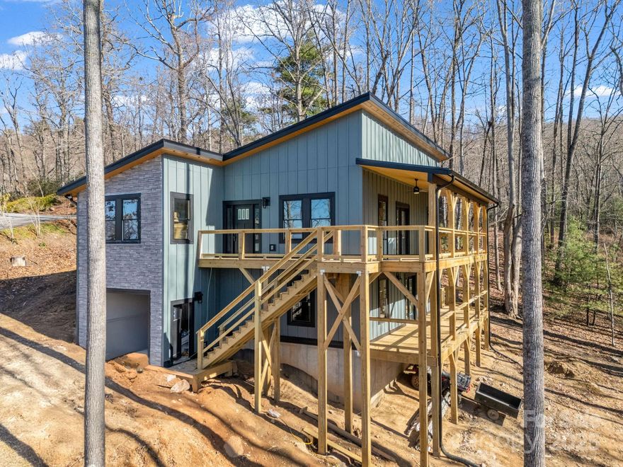 Discover modern mountain living in this stunning new-construction home located in Hendersonville’s coveted Rambling Hills neighborhood. Designed with contemporary elegance, this residence showcases expansive decks that frame breathtaking, long-range mountain vistas, ideal for relaxation or entertaining. Thoughtfully planned, the main level features two spacious bedrooms and one full jetted jacuzzi tub. Ascend to the upper level to find the Master bedroom and an inviting, open-concept living space filled with natural light, seamlessly blending into a stylish kitchen, perfect for culinary adventures. A flexible room adjacent to the kitchen makes an ideal office, study, or formal dining space, adapting to your unique lifestyle. Claim this remarkable property soon and personalize your dream home—select your favorite colors and modern finishes to make this architectural gem uniquely yours.