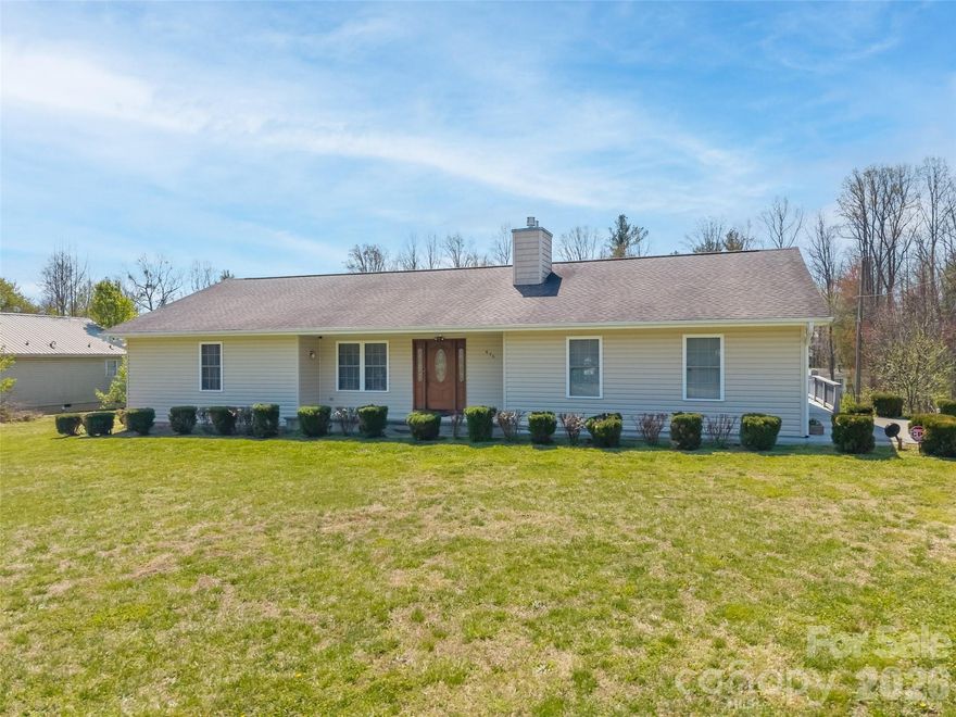 Looking for true one-level living with privacy, space, and incredible extras? This exceptional property on 1.48 unrestricted acres has it all! The main level features three generously sized bedrooms, each with its own bathroom. The kitchen is a standout with extensive countertop space, a breakfast bar, LG InstaView refrigerator, double ovens, flat cooktop, roll-out drawers, built-in pantry, and a spacious eat-in dining area. A cozy living room offers a fireplace and Hunter Douglas remote-controlled shades. The main level also includes a convenient laundry room with sink, central vacuum system, and a whole-house Generac generator. The walk-out basement expands your living possibilities with a kitchenette and half bath, ideal for multi-generational living, guest space, hobbies, or recreation. Outdoor living includes a composite deck with partial awning and a covered front porch. The attached double garage provides extra storage. A major highlight is the large workshop featuring a full bathroom and space to accommodate an RV, perfect for hobbyists, collectors, or anyone needing flexible extra space. Enjoy fruit trees, privacy, abundant storage, and no HOA or restrictions, great for gardening, homesteading, and more. Conveniently located near I-26, shopping, dining, and downtown Hendersonville.