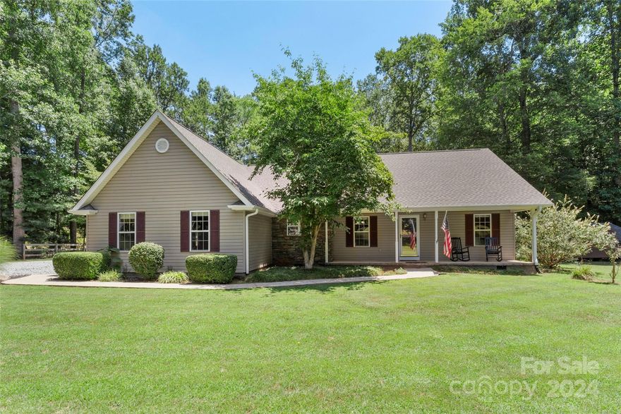 Welcome to 156 Hunters Trail! Located in the heart of Tryon, this home offers a large, level 1.6 acre lot complete with a creek. Well maintained home with a new roof in 2024, encapsulated crawlspace, freshly stained decking, and a private gazebo with a HOT TUB! Plenty of space for outdoor dining and entertaining as well as opportunity for relaxation. Numerous flower beds, trees, and the occasional wildlife visit! In addition to the attached 2-car garage, there's a 16x12 utility shed for lawn equipment storage. Open living space with a gas fireplace in the living room and split bedroom floor plan. 
Nearby shopping, dining, and entertainment in downtown Tryon. Convenient to Tryon International Equestrian Center, Hendersonville, Greenville, and Asheville.