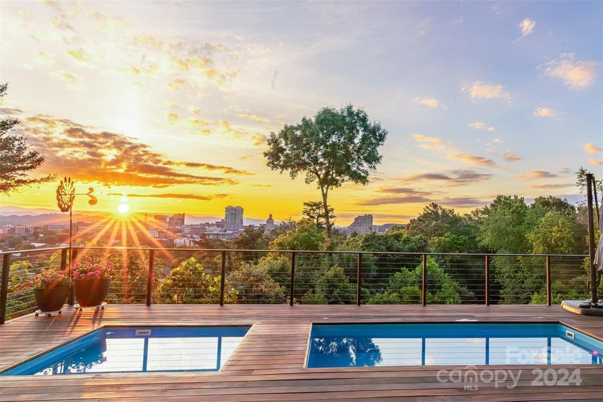 Skyline Serenity exudes modern luxury and boasts one of the best backdrops in the Eastern US -- 180 degree sunset views of the Blue Ridge Mountains juxtaposed with the twinkling lights from the eclectic city of Asheville. This visually stunning, Green-Certified home is an urban oasis where the 20’ soaring ceilings and triple slider doors remove the distinction between indoors and out. The Brazilian Tigerwood deck, floating heated plunge pool and spa are the foreground to the unbelievable skyline and mountain background. Host parties and entertain with ease in this “Smart” home (features attached to MLS) fortified with 23 tons of steel. Find space for every purpose: a flex space perfect for home office, yoga or artistic endeavors, a two car garage, multiple bedrooms with views and en-suite baths, a hardscape backyard and lavish four season living. Live above it all yet moments to downtown Asheville.