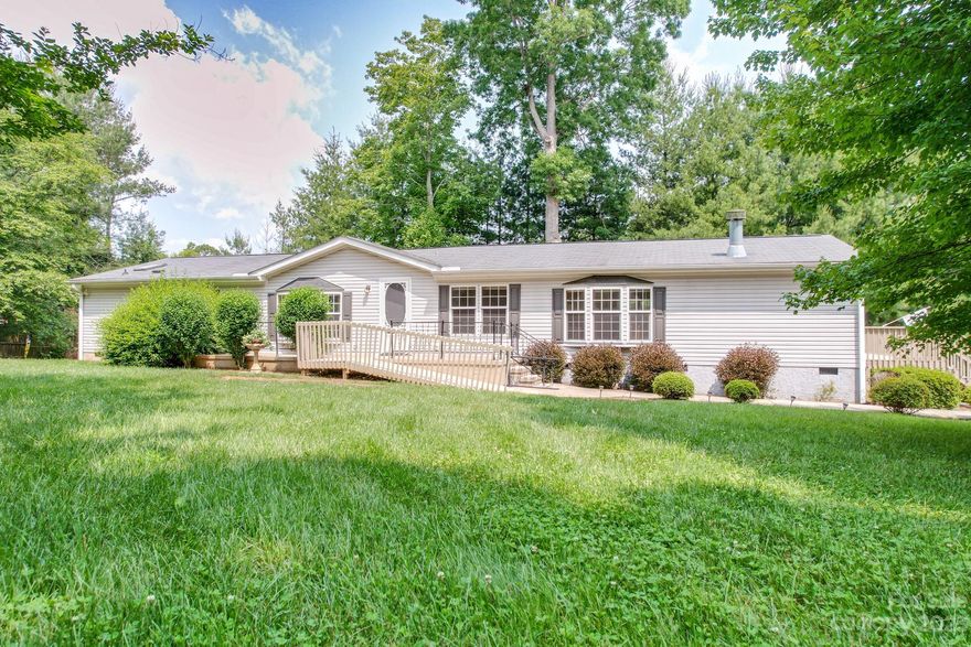 Tucked away at the end of a private road with scenic mountains and natural landscaping is this large 3 bedroom, 3 bathroom manufactured home. With over 2000 square feet, half an acre of property, and easily accessible, this home is convenient to maintain! The large windows, multiple skylights, and patio doors give an abundance of natural light to the home. The layout has so many different potential uses as well, with ample living space options in the den and living room, as well as a bedroom that is accessible through either a hallway door or through the master bedroom - could make an incredible office space! Living space is large and unconfined, open to the expansive deck off the kitchen. The amazing yard provides lots of privacy, peace and quiet. Located in Candler, off of Liberty Road, close to schools, shopping, and a short drive to downtown Asheville.