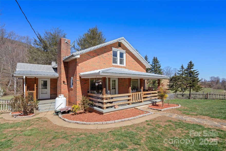 1937 brick cottage filled with original charm and smart updates, nestled in a lovely rural setting only 20 minutes to Downtown Asheville. On .82 acre of usable, flat to gently rolling land with creek, detached garage and outbuilding. Light and bright floor plan with original hardwood floors. Lots of updates - kitchen, bath, ceiling fans, remodeled master bedroom, new water heater, upgraded insulation and more! Move in ready! Enjoy the outdoors from the covered front porch or private fire pit area and spacious fully fenced front and back yard. Perfect for entertaining!