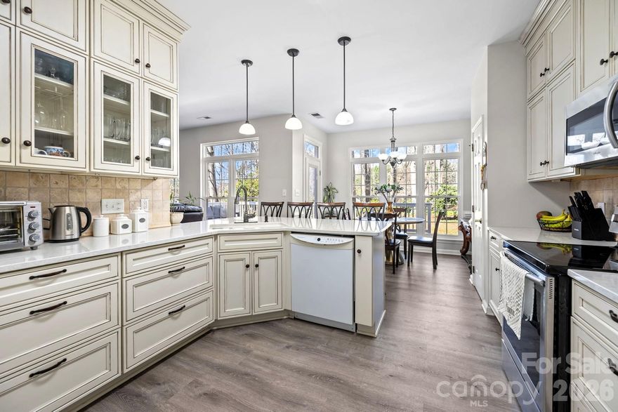Beautifully updated 2-story home in the sought-after Wiltshire Manor community in Steele Creek. This move-in ready home is filled with thoughtful upgrades and stylish finishes throughout. Enjoy new modern flooring on both levels and stairs, smooth ceilings (popcorn removed), and an expanded driveway for additional parking. The versatile floorplan offers both formal and casual living spaces, including a formal dining room and a formal living room currently used as a main-level office. The spacious family room is filled with natural light and features a cozy, real wood-burning fireplace with a classic white mantel—perfect for gathering and relaxing. The beautifully updated kitchen showcases high-end cabinetry with glass accents, elegant quartz countertops, and flows seamlessly into the breakfast area and family room, making it ideal for entertaining. Upstairs, the primary suite impresses with a cathedral ceiling and a renovated ensuite bath. Three additional generously sized bedrooms each include walk-in closets. The fourth bedroom offers a unique bonus—private access to an upper-level deck with stairs leading to the backyard, creating the perfect guest retreat, office, or flex space. Additional upgrades include newer windows, updated bathrooms, and a stylish garage door. Outdoor living is exceptional with a two-level deck spanning the back of the home, overlooking a truly special backyard. This gardener’s oasis is filled with lush, beautiful plants and flowers that are self-maintaining, along with a greenhouse, shed, charming bridge, and firepit—creating a peaceful, park-like setting with minimal upkeep. Tucked at the end of a quiet street and backing to a wooded natural area, this home offers privacy and tranquility. Enjoy relaxing on the welcoming front porch, perfect for rocking chairs. Conveniently located just minutes from Carowinds, shopping, dining, outlets, I-485, Charlotte Douglas International Airport, and Uptown Charlotte—this home truly has it all!