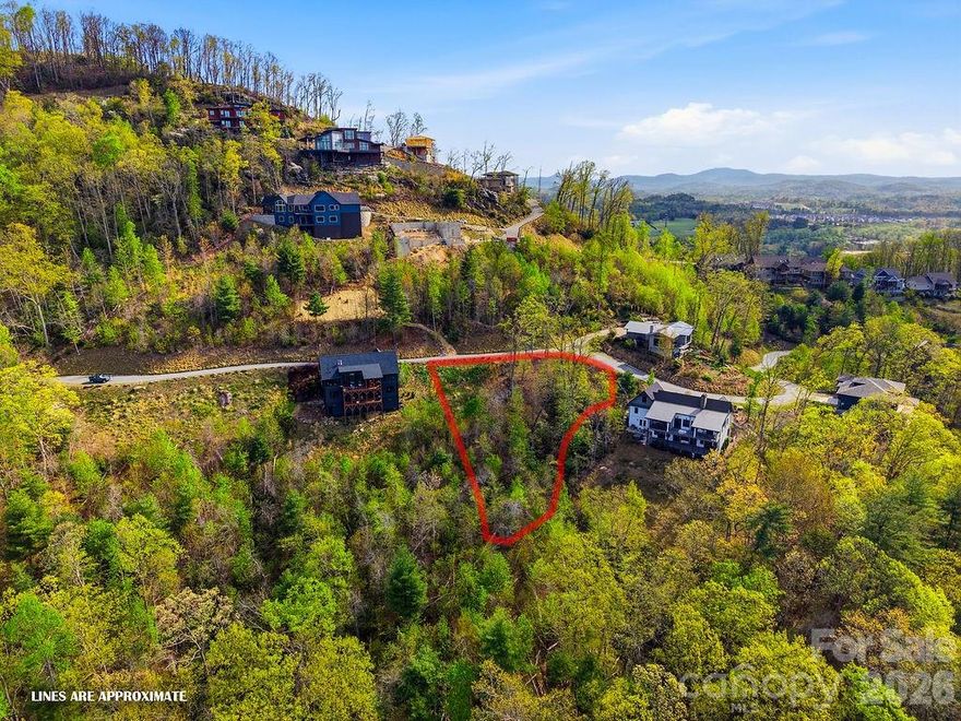 Positioned within the gated mountain community of The Boulders, 325 Curtain Bluff (lot W9) offers a rare opportunity to capture stunning long-range mountain views with unforgettable sunset exposures. This .57-acre homesite provides an exceptional setting for a custom residence designed to embrace the natural beauty of Western North Carolina, where layered mountain ridgelines and evening skies create a truly remarkable backdrop.

Thoughtfully prepared for future construction, the property includes a completed topographic survey and soil study supporting a three-bedroom septic system, allowing you to move forward with greater clarity and confidence in your building plans. The lot’s natural orientation and elevation are ideal for maximizing panoramic views, creating the perfect foundation for a home that seamlessly blends indoor comfort with outdoor living.

Located within a 56-acre gated enclave known for its scenic beauty and luxury homes, The Boulders is designed for those who value elegance, tranquility, and a connection to nature. With no required timeline to build, you have the flexibility to design at your own pace while investing in a community where surrounding homes reflect quality and craftsmanship. Conveniently situated just a short drive from Hendersonville’s vibrant downtown and the Asheville airport, this homesite offers the best of mountain serenity and modern accessibility. This is an exceptional opportunity to secure a premier view lot and begin bringing your vision of mountain living to life.