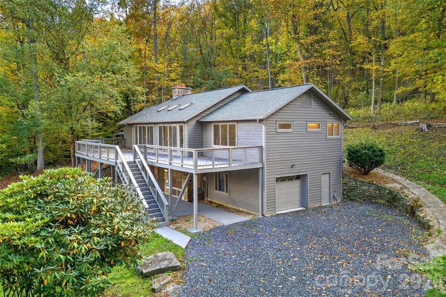 Perched at 3,300 feet within the Glen Ayre community in the Valley of Roan Mountain, this reimagined estate captures the perfect harmony of modern living in the Appalachian Mountains.  Thoughtfully redesigned through a comprehensive restoration completed in 2023, the residence presents as entirely new.

Crafted for comfort and efficiency, the home offers three  en-suite bedrooms, each complemented by expansive walk-in closets. Spa-inspired baths feature oversized tiled walk-in showers with both rainhead and handheld fixtures, while the primary suite elevates the experience further with in-suite laundry, a private water closet, and a luminous, nature-infused shower. Two of the suites are situated on the upper level alongside a powder room for guests.

Two expansive living areas—on the upper and lower levels—are anchored by striking stone-clad, wood-burning fireplaces. Locally sourced hardwood floors run throughout, while a bespoke 150-pound cherry mantel introduces a bold yet sophisticated focal point. Each fireplace, along with the interior chimneys and roof stack, has been meticulously reconstructed and refaced with native stone. A substantial covered woodshed, fully stocked with split wood, is discreetly nestled within the surrounding canopy. 

At the heart of the home, the chef’s kitchen is a true showpiece—featuring custom cabinetry, granite countertops, a designer tile backsplash, and an expansive island with prep sink. Premium GE Café appliances complete the space, that deliver both performance and style for everyday living or hosting with ease.

Outdoor living is equally exceptional. A sprawling 1,000+ square foot composite front deck, framed by contemporary wire railing, provides uninterrupted views of the Roan Highlands and surrounding valley. The private 8+ acre parcel offers a blend of natural beauty and usability, complete with a spring-fed pond, nearly an acre of mature fruit trees, and ample space for future expansion—whether an additional residence or curated structures. A thoughtfully executed landscape redesign enhances the home’s clean, modern curb appeal.

Behind the walls, the transformation is just as impressive. The home was taken down to the studs and rebuilt with all new systems and materials. Enhancements include closed-cell foam insulation on the lower level, advanced acoustic soundproofing between floors, and new fiberglass insulation throughout. All interior walls and ceilings have been replaced with industrial-grade drywall, complemented by locally sourced solid oak flooring, Sierra Pacific windows and sliding glass doors, and solid-core natural pine interior doors.

Every major system has been entirely replaced, including electrical, plumbing, and HVAC, alongside a complete lighting redesign featuring modern LED fixtures. The oversized heated garage has been finished with new walls, trim, and doors—including a windowed garage door with a sleek, side-mounted opener.

Residents enjoy the ease of HOA-maintained roads with modest annual dues of just $400. High-speed fiber optic internet, provided by the French Broad Electric Cooperative, ensures connectivity for work and leisure.

Ideally positioned, the property offers convenient access to some of the region’s most treasured destinations—just 10 minutes to the Appalachian Trail and the Roan Bald, and within easy reach of Bakersville, Johnson City, Burnsville, and Spruce Pine.

 Whether envisioned as a full-time residence or a refined seasonal escape, this is Appalachian luxury at its finest.