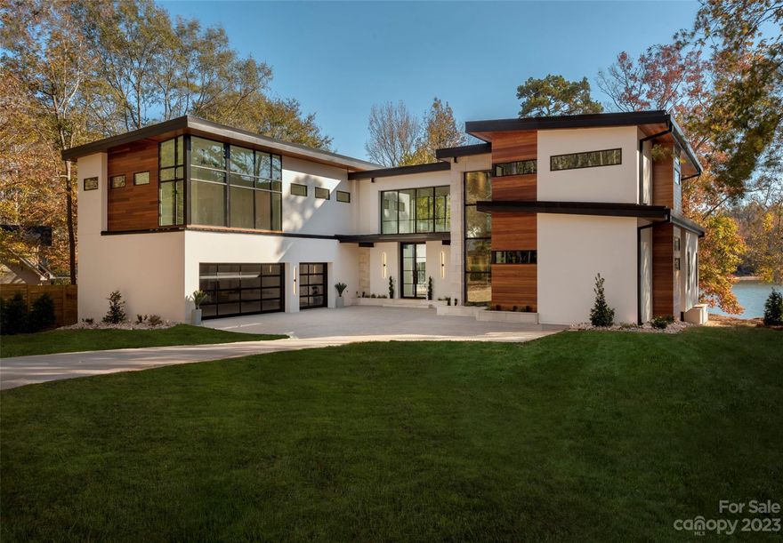 Discover your dream home just 20 minutes from uptown Charlotte, a clandestine lakefront modern home with unparalleled design aesthetic and livability. The exterior boasts smooth hard-coat stucco, imported limestone, and exotic cumaru wood. A 10' tall steel and glass door leads to a luxury pool with infinity edge blending into Lake Wylie. Inside, exposed steel beams and cumaru hardwood ceilings create an elegant atmosphere. The primary suite offers lake views, a custom closet, and a lavish wet room with a freestanding tub. The kitchen features a hidden prep pantry and overlooks a living area with a custom stone fireplace and folding glass wall leading to the infinity pool and outdoor kitchen.  Walk up the showpiece staircase next to a 22' stone wall to two different flex spaces and the rest of the bedrooms. The property is only 5 minutes from the airport with virtually no sound of air traffic due to the flight patterns. There is nothing this nice, this close to the city on the water!