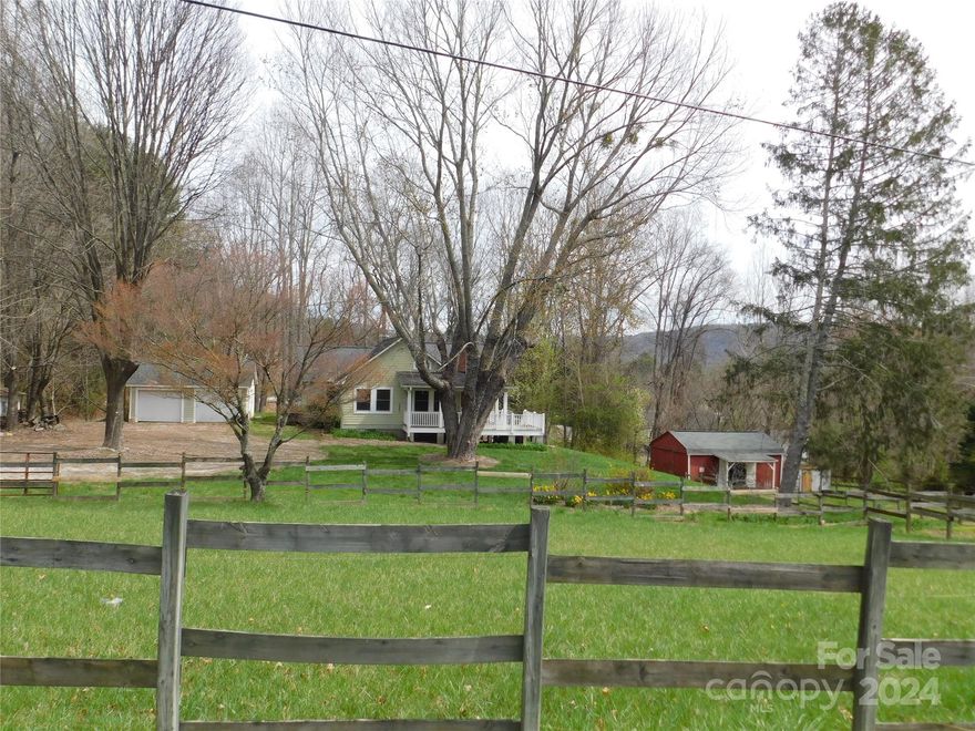 Mini Farm on 1.65 acre corner lot with 2 fenced pastures, raised bed gardens, small barn, detached 2 car garage & storage shed. Cottage/Bungalow style one level home with wrap around porch & circular drive. Open floor plan, kitchen with center island/breakfast bar, living room with vaulted tongue & groove ceiling, hardwood floor & wood burning stove. 3BR/2BA, (one bedroom has no closet & has been used as an office). Utility/storage room with outside entrance. 20 minutes to Historic Downtown Hendersonville shopping, restaurants & medical facilities. Winter mountain views. Needs a little TLC to make it your own.