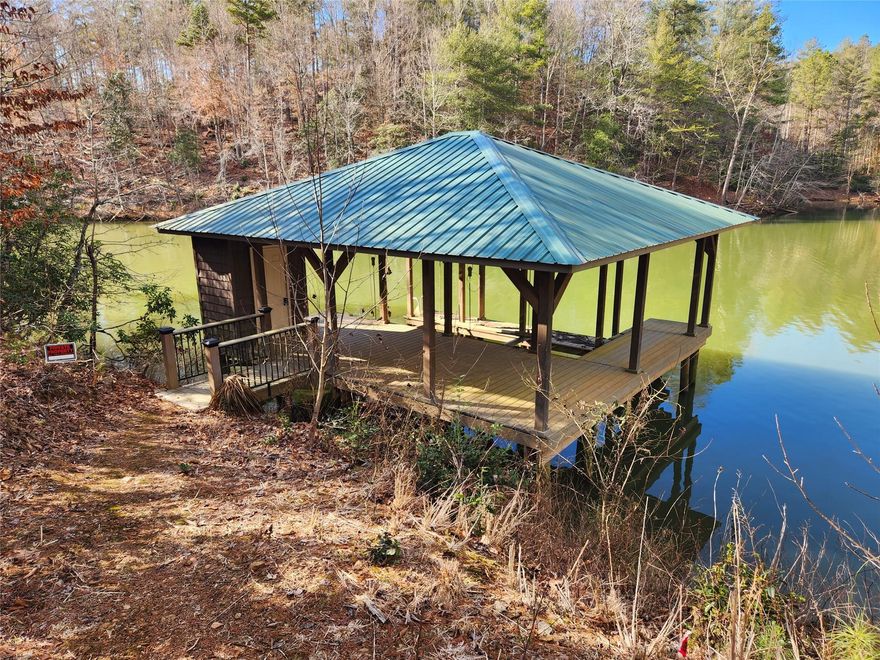 Lake Rhodhiss Lake front lot with over 400 feet of water frontage and super nice covered composite dock with boat lift in place.  Located in the gated Edgewater community this 1.5 acre property on a cul-de-sac offers great value.   It is the tough to find lot that features main channel views from the dock but also protection from the waves with its location just inside a nice deep water cove.   This is a great opportunity to have a dock you can use now and build your home later. Or a great opportunity to avoid the hassle of the delays, permitting process, and high prices of current dock construction.  The owner has paid for a survey which we will have by the end of the month and also applied for a septic permit through Caldwell county that we hope to have back by the end of march.   Two unique features of this community is that it allows for a guest house to be built on the property and also allows owners to camp up to one week per month on the property prior to construction.