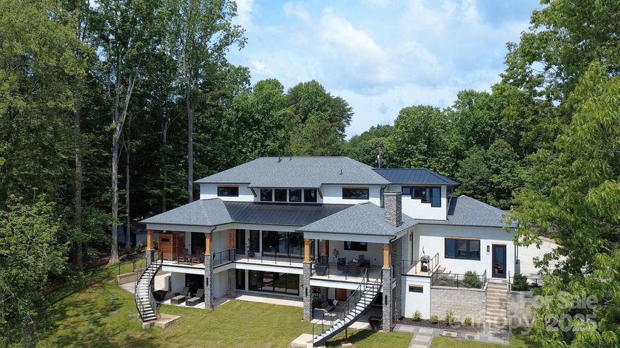 Modern-luxury on Lake Norman’s relaxed north side near the
State Park, just minutes from shopping and highway access. No HOA and 180° big-water
views highlight this nearly new home with expansive covered patios on both levels, five flex
rooms, dual laundry rooms, and epoxy-finished garages. Entertain at the cedar
indoor/outdoor bar with accordion window or the walnut basement bar with refrigerators,
ice maker, and dishwasher. Upgrades include a 26kW generator, EV charger, outdoor
cameras, oversized propane, balcony shower, PITT burners, built-in coffee, heated master
bath floor, Turkish marble sink, power shades, and four fireplaces. Curved balcony stairs
frame space for a pool. With 153 ft of shoreline, sandy beach, retaining wall, irrigation, and
a deep-water dock with 30-ft slip, electric, water, ethernet, and power washer—this property
is built for refined lakefront living.