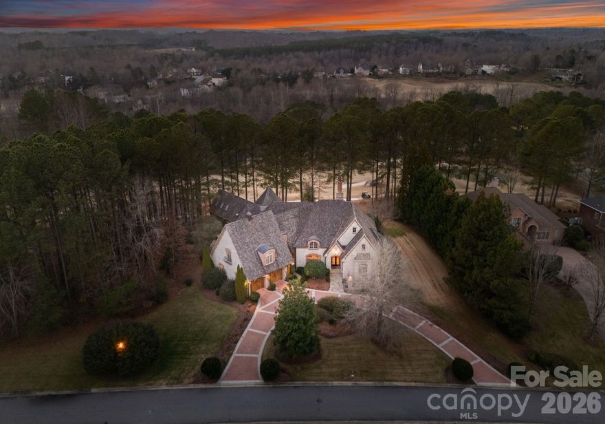 Stunning French Country Estate on three (3) combined golf course lots in prestigious Verdict Ridge, overlooking the iconic 16th Green. Natural stone exterior, brick detailing, and copper accents exude timeless charm. Wellness-focused features include an indoor HydroWorx Sports Therapy pool, Fitness Room with pro-grade flooring, Sauna, and Steam Bath - a private health retreat. Gourmet Kitchen with Viking range, stone hood, mural backsplash, wine bar with copper sink, and pass-through to golf-view Sun Room. Great Room with beamed/coffered ceilings and floor-to-ceiling stone fireplace. Main-level Primary Suite with multi-tiered tray, European-style fabric wall coverings, & private study. Expansive walk-in attic storage areas, perfect for additional bedrooms or bonus rooms (see example in attic space expansion PDF file attached).  Enjoy radiant heat floors, Artisan-inspired murals, flagstone terraces, putting green, Generac whole-house standby generator (automatic backup power), natural fenced area for furry loved ones, oversized garage with golf cart bay, and whimsical playhouse in garage apartment above. A rare blend of old-world charm and modern amenities - luxury meets lifestyle.