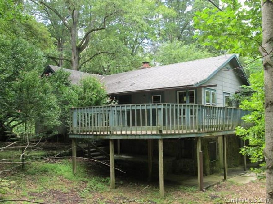 Vintage Cabin built by the Graves Brothers. Rustic, private with large great room, dining area,stone fireplace,2 bedrooms and 1 bath on main with wrap around porch. Basement level has kitchenette, living room, bedroom and bath-ceiling height under 7 feet so not including it in heated SQFT. Property also includes 2 other parcels, one on each side of the home for privacy. Two driveways.