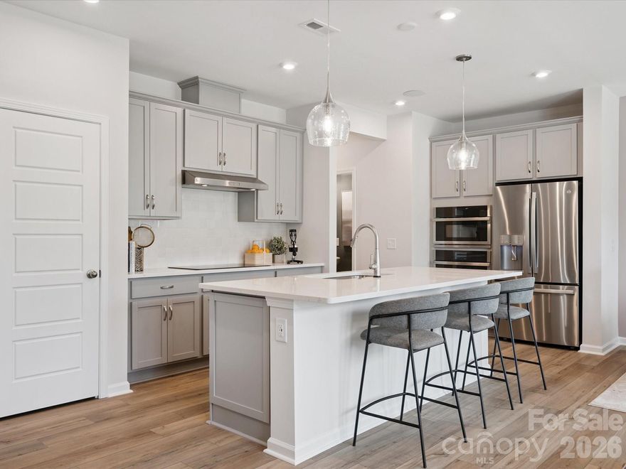 This two-story Millstone home pairs modern design with everyday functionality, offering three bedrooms, two-and-a-half baths, and a two-bay front-load garage with a full-length driveway. A Large 8' wide sliding glass door extends the main living area to outdoor living, creating an easy flow for entertaining or relaxing. The chef-inspired kitchen stands out with crisp white cabinetry, quartz countertops, striking black hardware accents, and premium panel shelving in the pantry, blending style with smart storage. Thoughtful finishes and an open layout make this home feel both elevated and welcoming.