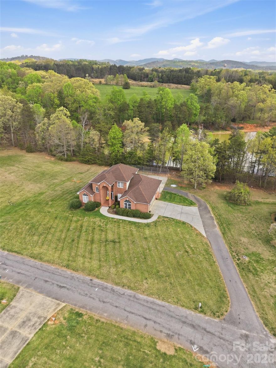 Exceptional all-brick executive-style home in Taylorsville, offering space, versatility, and comfort for every stage of life. Situated on Lots 16 & 17 totaling 1.52± acres, this property provides the perfect balance of privacy, usable land, and convenience to Statesville, Hickory, Lenoir, Wilkesboro, and even Charlotte.

The main level features a spacious living room, well-appointed kitchen, dining area, and mudroom, along with two bedrooms and two full baths. The primary suite is generously sized, with a luxurious ensuite bath and direct access to the back deck—also accessible from the living room—creating an effortless flow for indoor-outdoor living. Upstairs, two generously sized bedrooms share a full bath, offering room for family or guests.

The basement is a true highlight, with a large media room featuring a fireplace and lounging area, plus a finished craft/workout room and full bath. The unfinished portion includes a one-car garage, utility space, and ample room for storage or workshop use. Additional features include a two-car garage on the main level and quality all-brick construction throughout.

This home combines style, function, and location, offering the flexibility to entertain, work, relax, and enjoy life while remaining connected to the surrounding communities. Schedule your showing and see how this property can fit your lifestyle.
$649,900