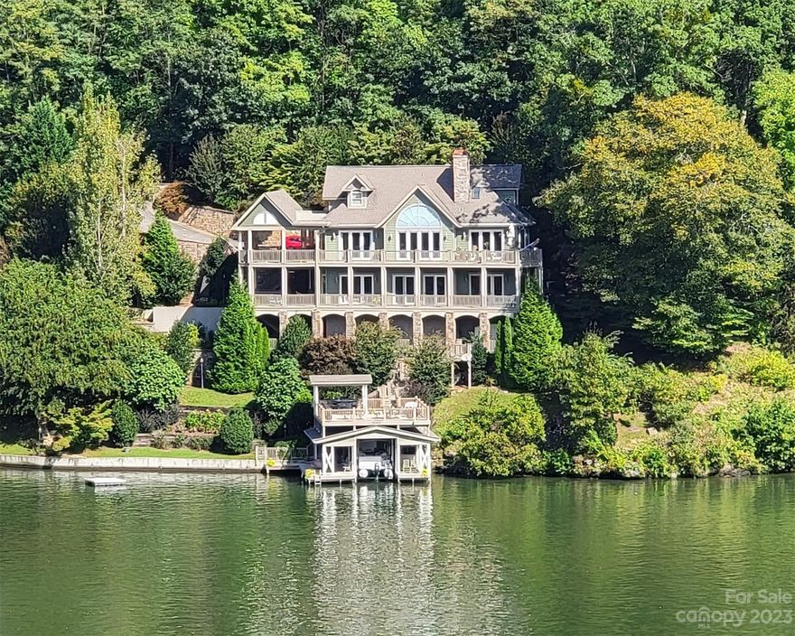 Magnificent home on Lake Lure’s main channel, situated to enjoy spectacular sunrises, sunsets and a direct view of Chimney Rock all year. The main level is open and bright with elements of architectural detailing and lake and mountain views from all rooms. Features two primary suites, one on main level and one basement level. Abundant outdoor living space includes a large covered deck with gas fireplace on the west side. A beautifully landscaped lot with an abundance of stone-covered retaining walls allows for stairs with landings to make getting to the lake easy. The covered dock/boat slip is topped with a 518 sq. ft. sundeck. Five HVAC systems for zoned comfort, whole house generator for convenience and comfort! Location is just 5 minutes to Town of Lake Lure and Village of Chimney Rock with no steep curvy roads to navigate. In addition to main living spaces there is a “sub-basement” with heat/AC that includes a large storage and fifth full bath (convenient for busy lake play days!).