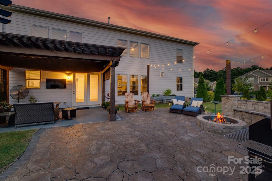 On an expansive and private lot, completely level with a fenced yard, this stunning home will leave you nothing short of impressed! A rocking chair front porch greets you and welcomes you in to a dramatic 2-story foyer and great room, flanked by an office and dining space. Immediately, custom detailing is seen throughout, with inset wood features, a stacked stone gas fireplace from floor to ceiling with built-in shelving and shiplap accents, iron stair balusters, LVP flooring through the common areas, and more! The chef's kitchen boasts a butlers pantry, stainless steel appliances, gas cooking, walk-in pantry, and generous island. Enjoy views from the entire back of the home to the showstopper of a yard - step onto the custom stamped concrete patio with pergola, the perfect spot to enjoy a football game or an evening by the stone fire pit with seating wall, all while you grill at the built-in cooking area. A shed gives extra storage, and with trees lining the entire yard, you can enjoy your outdoors in privacy. A bedroom and full bath round out the downstairs, and as you head upstairs you'll find another light-filled space with the sizable loft/bonus. The primary suite has a tray ceiling, spa bathroom with large soaking tub and walk-in tiled shower, dual vanities, and a custom closet. 2 additional bedrooms with another full bath gives plenty of space upstairs as well. The garage has epoxy floors and finished walls. With a convenient location just minutes from both the hub of Ballantyne, as well as all that Indian Land has to offer, and low SC taxes and top rates schools, Welcome Home!