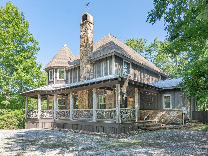 Introducing an extraordinary furnished home, nestled within walking distance of the majestic Pisgah National Forest and the serene French Broad River. This remarkable residence showcases impeccable craftsmanship, featuring meticulously hand-carved wooden doors and an awe-inspiring exterior and interior adorned with massive rocks and reclaimed wood. Step onto the flagstone and wood floors that grace the home, complemented by elegant granite counters and custom hand-carved cabinetry. The kitchen boasts top-of-the-line stainless steel appliances, while the exquisite trimmings, doors, and beams crafted from hemlock, chestnut, and oak were repurposed from a barn and silo that stood for over 150 years.  Outside you will find a private, wooded lot ideal for entertaining.  There is plenty of room for guests to gather around the firepit while enjoying the sounds of water flowing from the large rock waterfall.  A large, custom axe-throwing board also adds to the options for hours of outdoor fun.
