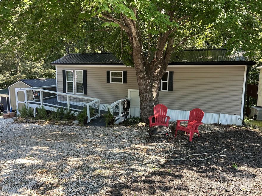 Nicely updated 2013 park model home on a deeded lot, sold fully furnished. Updates include fresh paint, LVP flooring, energy-efficient mini split unit for heating and cooling, washer and dryer, gutters with guards, and updated deck railings. Enjoy the peaceful, shaded backyard that gives you a mountain feel—right here at Badin Lake. The fenced backyard is perfect for your fur babies, and there's also a storage building for your extra gear. Located inside the gated waterfront community of Badin Shores Resort, an active community with amenities including a pool, beach, marina, playground, basketball and pickleball courts, putt putt, clubhouse, restaurant, and more.