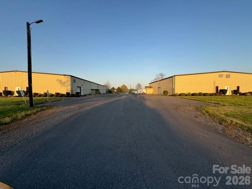 7.43 Deeded Acres, Manufacturing, Warehouse, Office Facility ; INCLUDES #3 Buildings, City Water, Sewer, Duke Electric *PLEASE SEE AERIAL VIDEO IN "ATTACHMENTS SECTION".
1.) Manufacturing Building w/ 21,559 Sq. Ft. built years 1986 & 2010 w/#4 Docks, #2 Drive-In doors, #1 Walk-Thru Door, #18' Center Ceiling Height, 14' Eave Height, Paved Parking Side & Graveled parking rear.
2.) Warehouse Building w/6,356 Sq. Ft. built year 1986 w/#2 Docks, #1 Drive-In Door, #1 Walk-Thru Door, #18' Center Ceiling Height, #14' Eave Height, Paved Parking side & graveled parking rear.
3.) Office Building w/3,212 Sq. Ft. built year 2014, #9 Private Offices, Breakroom, Conference Room, #2 Bathrooms,Drywall interior walls, Central HVAC, Paved Parking at side w/ concrete sidewalks front and rear. 
*Entire rear acreage is chain linked fenced w/ separate gated rear entrance off of Gatewood Drive.
*Separate paved gated entrance off of Wilson Drive to Manufacturing and Warehouse buildings
*Separate paved entrance to Office and Manufacturing buildings off of Wilson Drive.
** Current Tenant will be vacating entire facility by July 31st, 2026 ; Prior-to tenant vacating, a Non-Disclosure Form (attached) MUST be executed by prospective buyers Prior-To them entering the Manufacturing &  Warehouse buildings.
***Please contact listing agent for ALL Showings ; Do Not contact Tenant please!