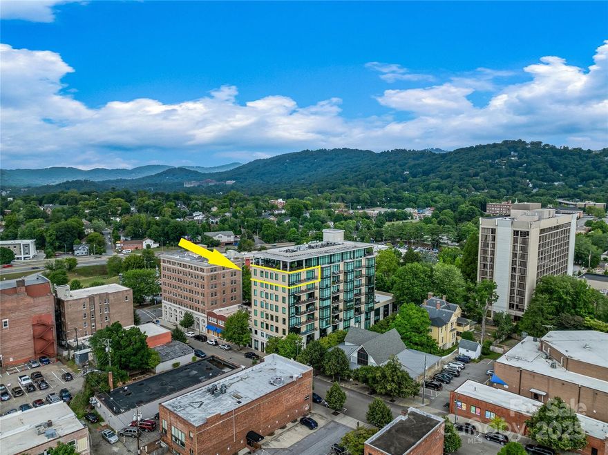 Located steps away from award-winning dining, entertainment, and cultural landmarks, this furnished and sophisticated 3-bedroom, 2.5-bathroom modern residence is located in vibrant Downtown Asheville. Featuring Viking stainless-steel appliances, the sleek chef’s kitchen transitions seamlessly to a large corner living room with sweeping city skyline and mountain views. A private balcony spans between the two rooms, offering a perfect spot for morning coffee or evening cocktails. Retreat to the inviting primary suite, complete with two spacious and separate walk-in closets and a large soaking tub in the ensuite bathroom. Two additional bedrooms offer flexible space for guest rooms or home offices. Two assigned and secured parking spaces are both pre-wired to accommodate EV charging stations and are conveniently located directly across from the elevator lobby. Residents enjoy shared use of a rooftop terrace, large flexible club room and private fitness center.