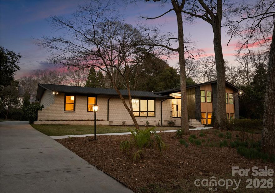 Welcome to 823 Wingrave Drive, a beautifully reimagined 5-bedroom, 4-bath residence located in the heart of Lansdowne, one of South Charlotte’s most established and sought-after neighborhoods known for its mature tree canopy, generous lot sizes, and exceptional proximity to the city’s best amenities.

Thoughtfully renovated from top to bottom, this split-level home blends timeless architecture with elevated modern design. A striking steel front door opens to a light-filled foyer where wide-plank white oak flooring flows throughout the main living spaces, creating a warm and sophisticated foundation for the home’s contemporary finishes.

At the center of the home is a stunning chef’s kitchen designed for both everyday living and entertaining, featuring Taj Mahal quartzite countertops, ZLINE professional appliances, custom cabinetry, and designer lighting. A custom glass-front wine display adds a dramatic focal point and perfectly complements the open-concept living and dining areas.

The main-level primary suite offers a private retreat with a spacious walk-in closet and a beautifully appointed spa-style bath complete with dual vanities, an oversized freestanding soaking tub, and an expansive walk-in shower. Upstairs, a rare second primary suite provides additional flexibility for guests or multigenerational living, along with two additional bedrooms and well-appointed baths.

The lower level creates an inviting secondary living space with a wood-burning fireplace, full laundry room, and an additional bedroom or office, ideal for work-from-home or guest accommodations.

Situated on nearly half an acre, the outdoor living experience offers both privacy and possibility. The expansive yard and patio with turf inlays provide ample space for entertaining, play, or the addition of a future pool. Completing the property is a brand new 2-car garage with extra dedicated interior storage, adding both convenience and functionality.

Perfectly positioned within the Lansdowne community, residents enjoy easy access to SouthPark, Cotswold, Uptown Charlotte, top dining and shopping destinations, and highly regarded schools including Lansdowne Elementary and East Mecklenburg High School.

Blending thoughtful renovation, flexible living spaces, and an unbeatable location, 823 Wingrave Drive offers a rare opportunity to experience modern living in one of Charlotte’s most beloved neighborhoods.