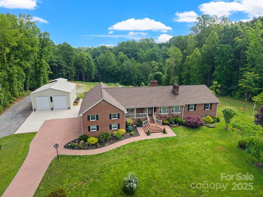 Welcome to this beautifully maintained 4-bedroom, 4.5-bath brick ranch home in the Belews Creek community. Step into the inviting living room featuring hardwood floors, recessed lighting, and stone fireplace. The kitchen is a chef’s dream with granite, double oven, cooktop, pantry, island with seating, and a breakfast area. A cozy den with a wood-burning fireplace and office/bar area. The primary suite offers his/hers walk-in closets and sitting area. The en-suite bath features double granite vanities and lg shower. The 3 additional bedrooms have new carpet and one bedroom that can serve as a second primary suite. The finished basement includes a bonus room, flex space, and a full bath, with its own walk-out entrance to the back patio. The property also features: 30x40 detached workshop/garage with a 9,000 lb lift, storage building, and large carport provide endless options for hobbies, storage, or small business needs. Enjoy peaceful country living with no HOA or deed restrictions.