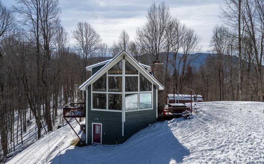 Enjoy your own piece of the NC Mountains containing 6.43 unrestricted acres with a 4BR, 3BA home that has over 2300 sq ft, multiple levels, a garage, hot tub, wood stove, & so much more. The great room has a magnificent wall of windows with a stone chimney & woodstove to cozy up to in the winter months. The kitchen, with stainless steel appliances, new dishwasher, & copper sink, along with a bonus room, a full bathroom, and two bedrooms are on the main level. Upstairs you will find an open loft and a spacious primary suite with a balcony, WIC, & full bathroom with walk-in tile shower & double vanity. In the lower level you will find another large sleeping/living space, full bathroom w/laundry, a bonus room w/closet (was one bay of the garage), & garage parking. The stone chimney services both the inside great room woodstove & the outside fireplace where the hot tub is located. There is an RV hookup & water hydrant on the property. Wildlife is abundant and seen on a daily basis.