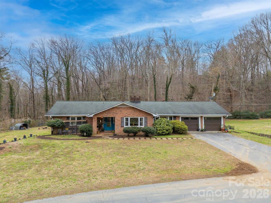 Only minutes from downtown Tryon, this sprawling brick ranch represents a rare find.  Situated on a corner lot bordered by intersecting creeks, this home features close-up mountain vistas on an unrestricted 1.6 acre parcel.  Single level living w/spacious living room and dining area w/gas fireplace and newly installed vinyl plank floors.  Kitchen boasts tons of cabinet space plus a cozy breakfast nook w/slider onto rear deck.  Just off the kitchen you'll find a flexible use space w/kitchenette and sitting area alongside another bonus room/den complete w/built-ins and wood-burning fireplace.  Head down the hall to a shared full bath, a bedroom and the primary bedroom w/dual closets.  Deep, covered back deck leads to a fenced & mulched area perfect for your furry or fluffy friends.  Basement areas can definitely be utilized for storage, a workshop, or even for as a canning shed.  The backyard slopes very gently to the creek w/the property line actually crossing the creek.  If you've been searching for a spot offering a little elbow room without being remote, this property may be the perfect fit for you.