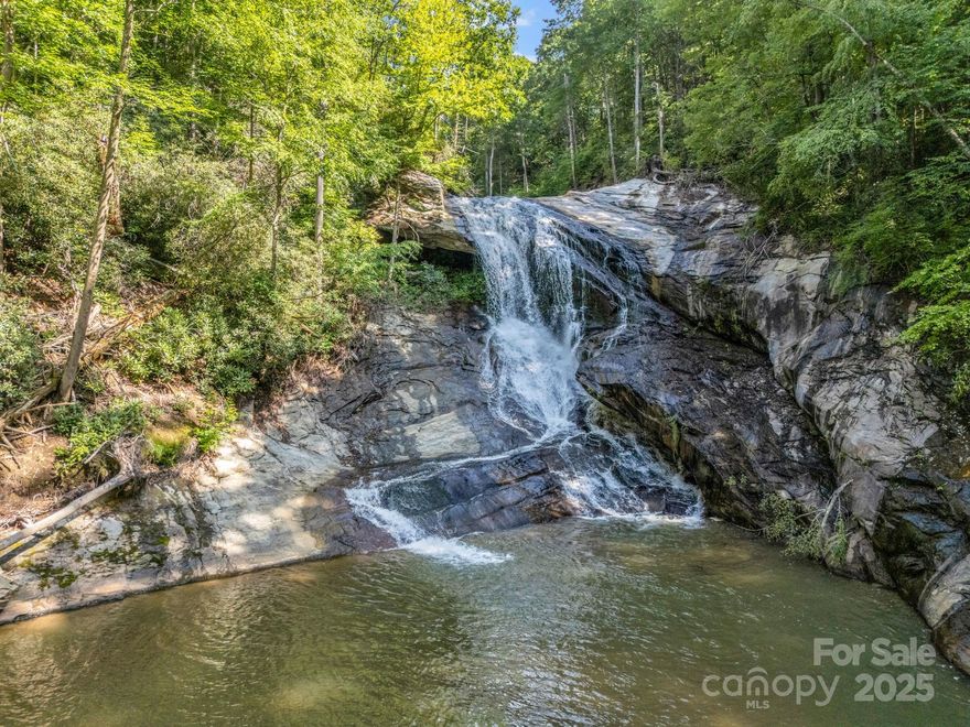 Incredible 52+ acre waterfall property between Black Mountain and Lake Lure! There
are 3 gorgeous waterfalls and some swimming holes that would rival anything you would see in
nearby national forests. Flat Creek is the named stream that runs through the property. Prior to Helene, the house was renovated and operated as a successful vacation rental. The storm damaged the home beyond repair and it was approved for removal by Buncombe County (no timeline known for removal at this time). The most likely build sites on the property are located on the southeast section of the parcel, where you enter the property. Let your imagination run wild with new hiking trails, fishing adventures, picnic spots, and more! OPEN USE ZONING! There is a hiking trail that runs up the east side of the stream to the top of the property, with another steep spur trail that provides access to the upper waterfall. Land has 2 access points; the SE corner and a right-of-way on the west side via a culvert over a small tributary (but the bridge is gone). However, the west side right-of-way may have changed due to Helene (see new survey). Click Virtual Tour link for video/survey. A map of property showing the main features is available from agent. The adjoining parcel to the west is also on the market (See MLS 4325345; Buncombe County PIN: 0625-06-0575-00000). This property offers another 123+ acres, a gravel road to a level build site, trails, and rock outcroppings. Combining both of these properties would create a beautiful estate unlike any other in Western North Carolina! With both properties, there are countless opportunities for hunting, recreation, and additional trail building!