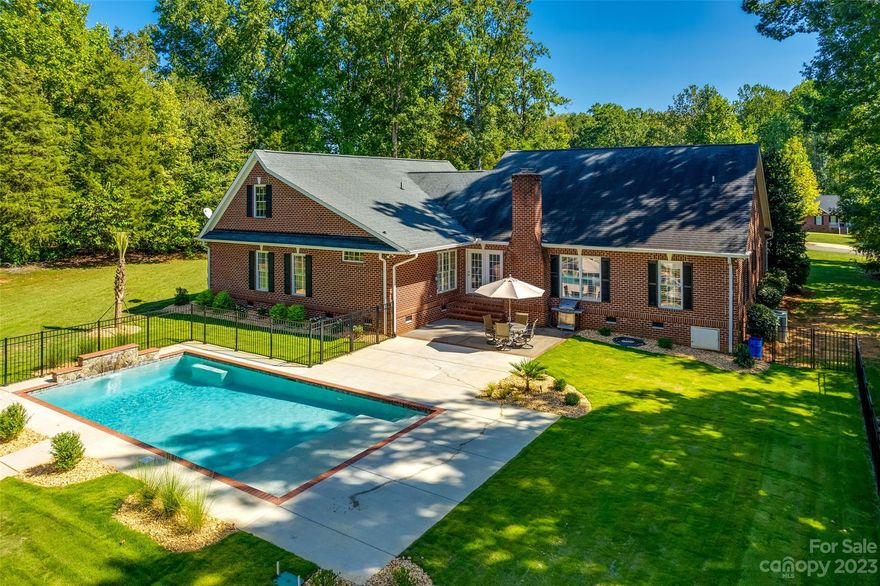 A slice of paradise on close to an acre, this all brick home has a new (2022) saltwater pool boasting waterfall feature, sun shelf, and gorgeous landscaping! The detached garage/workshop can hold another 2 cars, and has an upstairs for storage or future potential. As you enter from the rocking chair front porch, you are greeted by gleaming hardwoods and heavy molding details. The vaulted great room is grounded by a cozy fireplace, and has built-ins for extra storage. The kitchen has been updated with glass pendants, and has expansive granite counters and cabinet space for cooking and entertaining. The primary bedroom has a huge, recently added, walk-in custom closet (now there are 2!), and remodeled bathroom with new tile shower, new tub with jets, & more! Water filtration system was added, irrigation in the backyard, too many features to list - see attachments for all the awesome upgrades that have been done since 2022. With low SC taxes, don't miss the opportunity to call this home!