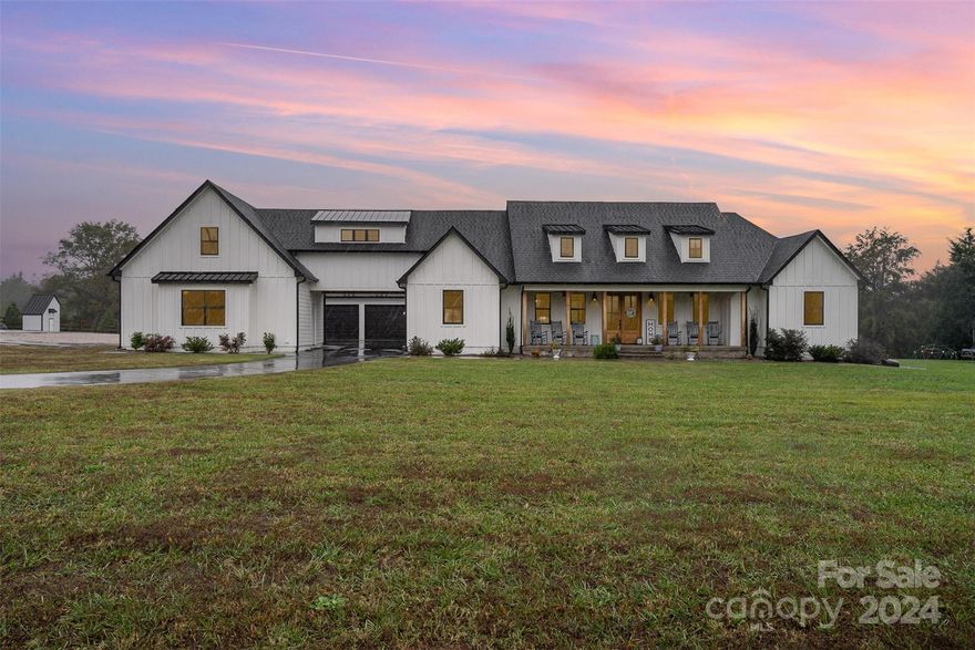 This exceptional modern ranch farmhouse sits on over 3 acres of land with no HOA. Featuring 5 bedrooms and 4.5 baths, the home showcases an open floor plan with vaulted ceilings, exposed beams, and impeccable craftsmanship throughout. Prepare dinner on the huge kitchen island and then relax in the spa like primary suite featuring free standing tub and huge shower with rain head. A wheelchair-accessible ensuite located off the garage with the ramp ensures accessibility, while custom trim work adds character to every room. Step out back through the screened in porch to the heated inground pool. Home has attached 3-car garage with pull through and 2-car garage connected to main home by an enclosed bridge. The nearly 3,000 sqft barn features 3 additional garage spaces, an RV bay, a car lift, murphy bed, kitchenette, flex space, office and two full baths. With spray foam insulation for energy efficiency, this home offers the perfect balance of luxury, space, and practicality.