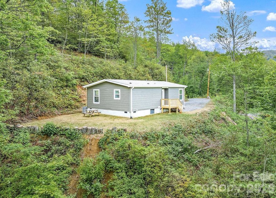 Motivated seller & Priced to SELL!  Welcome to your little piece of heaven in the Great Smoky Mountains! Perched on a knoll at an elevation to keep you so cool!Escape to your own private retreat. New Construction in 2024, this custom home offers the perfect blend of serenity, views & opportunity.  Situated on a total of 1.61 acres across 2 separate lots, you'll enjoy incredible privacy & panaramic mountain views that seem to stretch on forever from the front porch. The homesite has already been thoughtfull cleard, creating a ready-made opportunity for future expansion-whether you envision adding sq footage to the existing home, garage, workshop or creating the ultimate outdoor entertaining space. The groudwork is done-bring your vision. The 2nd lower lot is also cleard and buildable, offering even more flexibility. Build another home, create a family retreat, develop an income producing rental or simply preserve it for enhanced privacy & expanded longh range views.  A rare opportunity!  Inside you will find an almost new custom home featuring: a Spacious bedroom & beautifully appointed bath. Oversized great room filled with natural light. Stunning kitchen with upgraded cabinetrty, gorgeous contertops, & large island perfect for gathering. Dedicated space for a home office or computer niche--ideal for remote work.  10x20 outbuilding/workshop for all your needs.
Tucked away in the mountains, you'll feel completely immersed in nature, yet only 6 miles to Maggie Valley & 20 miles to Cherokee. Hiking, 4-wheeling, fishing, & outdoor adventures await right outside your door.
HOUSE, WELL & SEPTIC COMPLETED IN 2024. Move-in ready with room to grow! Take a look TODAY--your
mountain dream (with room to expand)is waiting for YOU!