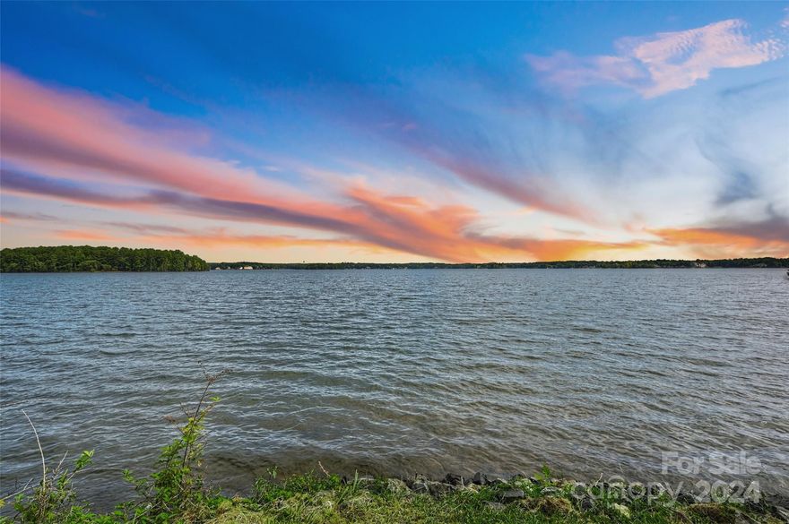 This exceptional property offers one of the most amazing waterfronts on the Brawley School Road peninsula, situated just beyond The Point on the highly coveted Stone Marker Road. A true peninsula lot, it features 319 feet of shoreline, showcasing magnificent sunrise views over the Main Channel. The expansive covered dock, recently updated with Trex-like decking, is grandfathered in and perfectly positioned on the side of the property in a protected cove, ideal for swimming. The home itself includes four bedrooms, three bathrooms, beautiful wood floors, a charming wood-burning fireplace, and spans approximately 2,200 square feet.