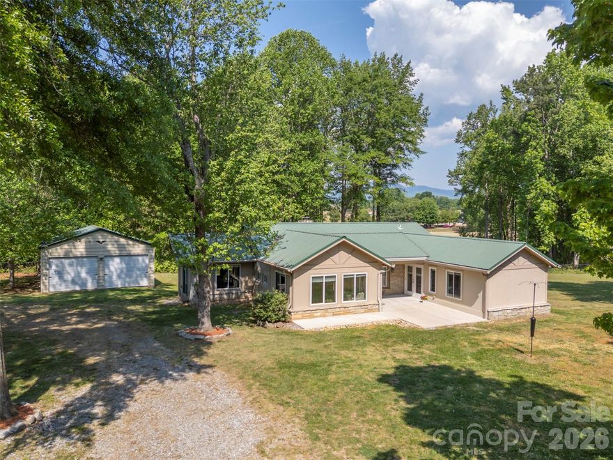 Private Campobello retreat on approximately 5.5 acres beside Links O’Tryon Golf Course offering a rare combination of character, flexibility, privacy and utility. Tucked away at the end of a quiet, country road, the renovated main home blends original charm with thoughtful updates including preserved granite walls from the original 1947 structure, bead board walls and ceilings, hardwood and flagstone floors, a gas log fireplace, updated baths with frameless tile showers, a designer kitchen with granite counters, custom cabinet features and an easy flow into the main living spaces. A major 2007 refurbishment with a family room, larger primary suite (with ensuite), walk-in closet, porch, pub/TV room, creating a lay-out that feels warm, inviting and highly livable. Outdoor leaving is equally appealing with a large deck, broad lawn, mature trees, golf course frontage, and spectacular mountain views that give the property a true Foothills feel. There is a detached 2-car garage, but what truly sets this property apart is the 2008 out-building designed for far more than an ordinary garage space. The approximately 2600-square-foot barn/garage includes a one bedroom apartment with full kitchen and bath, a  heated and cooled exercise room or office, loft storage, and over-sized space suited for a 45-foot RV with a 14-foot overhead door, 30-and 50-amp service, and sewer hookup. All features that make it especially compelling for automotive, hobby, or business-minded buyers. The facility includes a car/truck lift, air compressor, and installed air lines, giving it strong appeal for collectors, RV owners, trades people or anyone seeking serious workshop or auto-body-shop potential. Addition practical benefits include no HOA, high-tech security coverage for home, apartment and shop, underground utilities, public water, and septic service. A convenient location near Landrum, Tryon, Greenville, Spartanburg, Hendersonville and the North Caroline line. With acreage, guest quarters, RV storage, workshop functionality, and a beautifully updated home in a peaceful golf course setting, this is a uniquely versatile foot hills property that is difficult to duplicate.