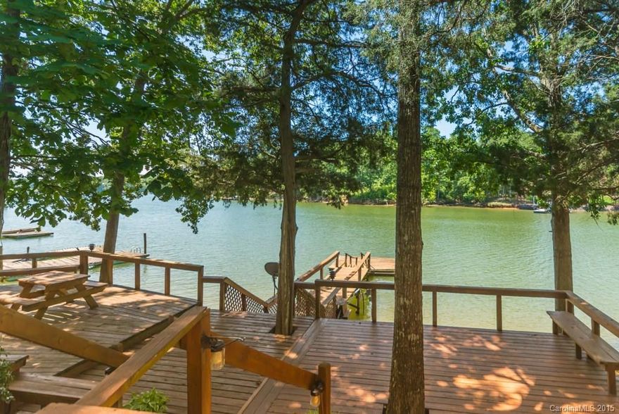 Waterfront Retreat! Nestled in a quiet cove with deep water, this all-brick home is the ideal spot for a weekend getaway place. Large kitchen with breakfast nook. Family Room has a great view. Wrap-around screened-in porch. Lots of mature trees provide some fabulous shade over the expansive decking, making this a great place for outdoor entertaining. The house is close to the water for quick easy access to the pier and floating dock. 2 outbuildings for storage. Clover Schools.