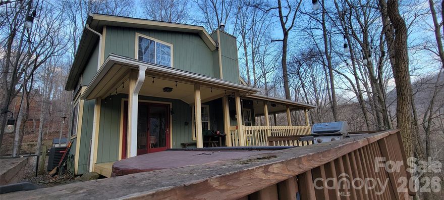 LOCATED IN THE MAGGIE VALLEY COUNTRY CLUB ESTATES - This 2 Br/2 Bh with loft, turn key/completely furnished mountain cabin with wrap-around porch & drop deck for large hottub. Greatroom with gas log FP. Primary bedroom on main level, central heat & air.  This 2 story home sits on 1.76 acres of 2 lots.  You can experience the sounds of babbling artificial waterfall near private rear porch and hot tub deck with mountain views.  Additional views can be had with tree trimming or cutting.  Greatroom area with high vaulted wood ceilings, central heat & air. All paved easy access to long driveway of home.  The atmosphere will provide guests with a true mountain getaway feel.  Outstanding proof of rental history makes this a perfect investment opportunity in the heart of the popular tourist destination of Maggie Valley.  A wonderful choice for your primary or vacation home.  Maggie Valley Country Club membership amenities available, including golf, swimming, tennis and dining.  Located approximately 5 minutes from downtown Maggie Valley and 10 - 13 minutes to beautiful Lake Junaluska and downtown Waynesville with shopping, fine dining, festivals, etc.