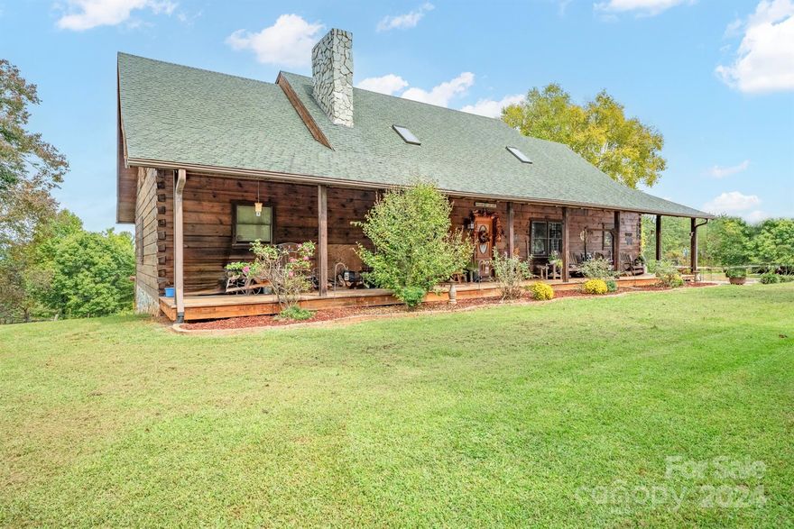 This listing offers a rare opportunity to own a 21-acre farm in the NC foothills, with breathtaking views of the Blue Ridge Mountains. Main home is custom-built log house with 4 bed and bath, includes a spacious living room with a stone fireplace, large kitchen w/island, and a huge laundry room. Primary bedroom on the main floor boasts mountain views and a luxury en-suite bath, all granite counters, cathedral ceilings, and open-concept living. The basement serves as a second living area with an open kitchen, dining, and LR, along with a bedroom, full bath, and W/D. This makes it perfect for multi-generational living or guest accommodations. The property also includes a second home, 3 bed 2 bath DW mobile home, offering additional housing or rental income potential. Property includes a large barn with four stalls, a tack room, hay storage for 1,200 bales, and roping arena with return alley strip and automatic chute. Low agricultural taxes and is enrolled in an agricultural program!