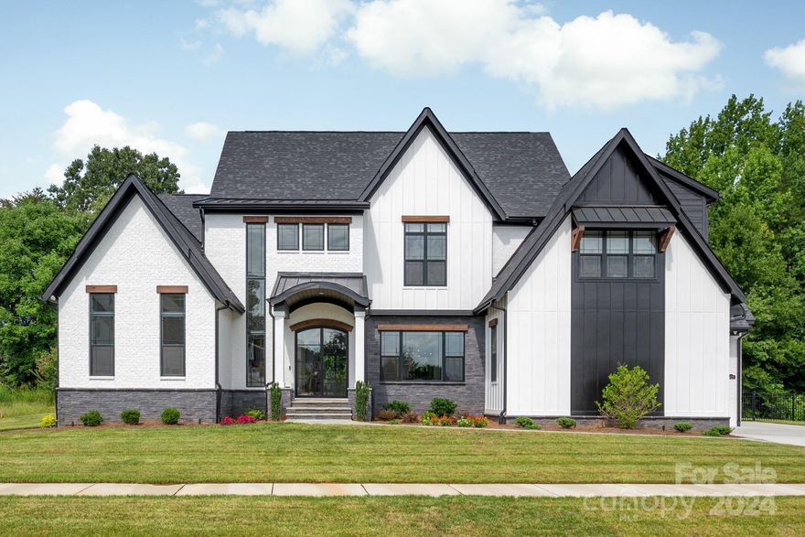 Enjoy all the details of a custom, award-winning home without the wait & unpredictability of building from scratch.  Completed in 2022, this stunning home features a jaw-dropping primary suite with wet-room, separate closets & access to the backyard oasis with its gas fireplace, outdoor kitchen, Phantom screens, in-ceiling heaters, saltwater pool, & therapeutic hot tub. Add'l main floor guest suite offers zero entry shower, and barn door access off the kitchen. A glassed wine room, separate bar, dining room, living room with fireplace, and gourmet kitchen with breakfast room flow effortlessly & are bookended with a private office, hidden scullery & laundry/mud/craft room. Dramatic curved staircase leads to rec room, media room, 2 add'l en suites & add'l exercise/bonus room. Shiplap hidden door in Suite #4 to unfinished storage. 3 car garage w/epoxy floors & EV charger. 4 zone HVAC, 2 tankless water heaters, outdoor sound system, security system with 6 exterior cameras, and more!