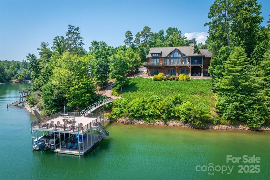 Experience luxurious lakefront living in this stunning custom home featuring breathtaking long-range waterfront views. Nestled on a serene shoreline, this residence showcases a dramatic cathedral ceiling and a spacious great room centered around a cozy gas fireplace. Main floor hosts the primary suite with a spa-like bath and  spaciouswalk in closet.  Entertain in the gourmet kitchen, equipped w/high-end appliances, large island & hidden walk-in pantry. Enjoy year round outdoor living on the screened porch with a wood-burning fireplace. Guests will love two additional bedrooms in the lower level, each with ensuite bath, one with private sauna. The lower level also boasts a wine cellar, wet bar, and easy access to the floating covered aluminum dock. A scenic fire pit area invites evening gatherings by the water. Crafted with rich poplar bark & cedar siding complemented by a 2-car attached garage, this home is the perfect blend of rustic elegance & modern convenience.  Offered turnkey!