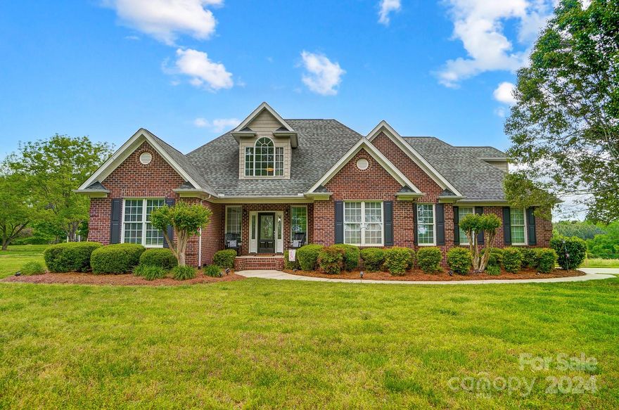 Full brick 1.5-story home with more than enough space for entertaining both inside and out. Primary suite with garden tub, two vanities, and separate shower/water closet. Dedicated home office with private bath. Split bedroom plan; secondary bedrooms share full bath with double vanity and private water closet on main level. Stone fireplace in living room. Beautiful wood paneled cathedral ceilings in living and dining rooms! Custom kitchen w/ stainless steel appliances, Corian countertops, center island plus breakfast bar and dining area. Ample counterspace for food prep with lots of cabinets for storage.  Laundry room with built-in cabinets.  Bonus room and full bath upstairs.  Large, walk in attic storage space.  Large, 1.5-acre level lot. Rocking chair front porch, back deck off the dining room plus lower patio area. Large tractor shed included "as is" with home purchase.  Two-car garage with storage closet.