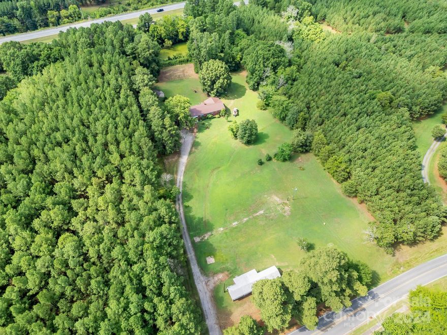 Original Full Brick Home has potential for an upfit and single wide manufactured home is being sold "as-is" of no value. The manufactured singlewide home has a month to month lease and fronts Old Airport Rd. A former gas station fronts NC Hwy 49 and no longer has pumps but the tanks remain in the ground. High visibility and entrances from 4 lane highway 49 and state road. Commercial possibilities abound. Property is 1/8 mile from Cabarrus Arena and Events Center.  Please view the home knowing it has been vacant for quite some time.