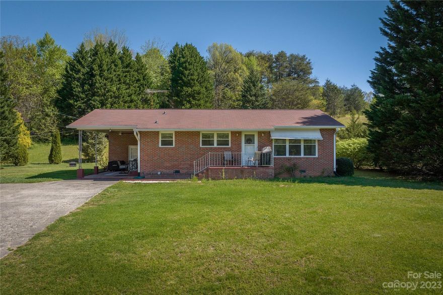 Brick ranch home on 4.7 acres! The home has been well-maintained.  Original wood floors! Living room opens onto updated kitchen and eat-in area. Plenty of cabinets and countertop space. Ceiling fans.  Carport can also be used as a patio - nice with the large fan! Acreage behind home is mostly wooded. Charming home! Must see!