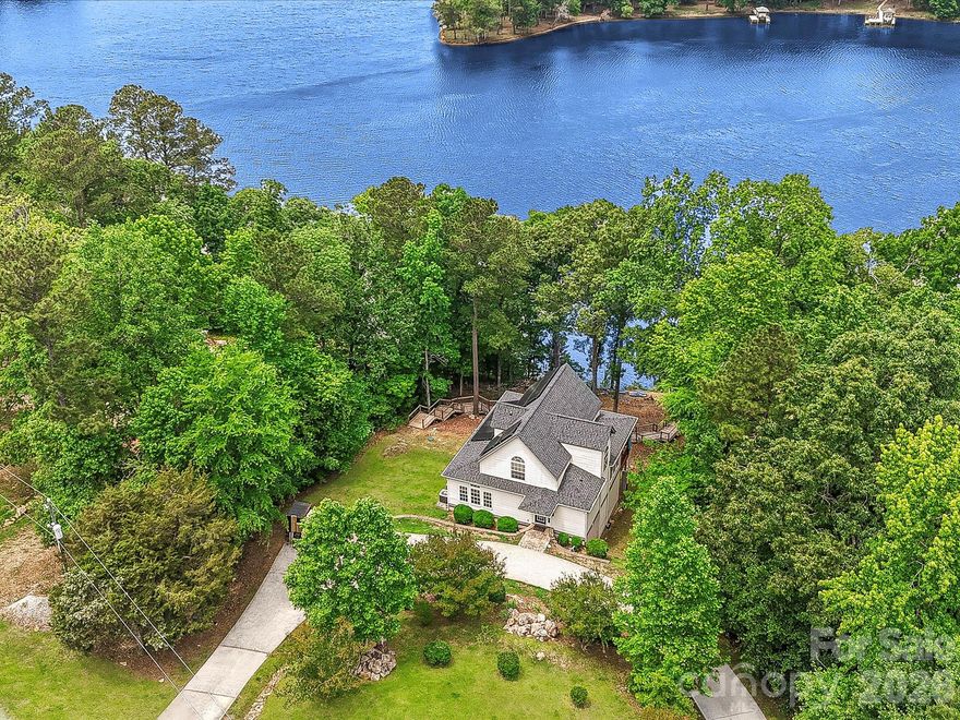 Enjoy lake life at its finest! Situated on a deep-water cove with incredible scenic views, this stunning property offers it all, from relaxing on the new dock with new covered boat lift to enjoying the expansive covered rear porch surrounded by trees overlooking Lake Wateree.

Lovely open floorplan with a beautifully renovated kitchen featuring abundant new cabinetry extending to the ceiling, white quartz countertops and island, hammered copper sink and hood, stainless steel appliances, and adjoining scullery/pantry with additional cabinetry and exceptional storage.

The vaulted two-story great room is flooded with natural light from a wall of windows showcasing lake views. The primary bath features dual sinks, a jacuzzi tub, and walk-in shower. All secondary bedrooms are generously sized.

Finished walk-out basement with easy access to the walkway leading to the lake features a huge rec room complete with wet bar, perfect for entertaining and ideal for possible second living quarters. Basement also includes two bedroom a full bath, and large utility room offering walk-in storage.

Additional highlights include a circular driveway for convenient access including ample parking for boats. Solar panels with a Tesla Powerwall power backup system installed in 2023. Conveniently located just a short drive to I-77 and nearby popular outdoor attractions and recreational activities including the U.S. National Whitewater Center and Carolina Adventure World, with easy access to local shopping, dining, and popular Lake Wateree area restaurants. Don't miss this gem!