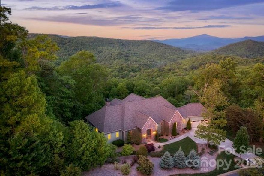 Exceptional privacy and jaw-dropping southeastern views of Li'l Pisgah — with lots of space to entertain and play. Private, secure, and luxurious top-of-the-hill, higher elevation retreat offers both long- and short-distance views. Whip up culinary creations in the fabulous kitchen with chef-inspired appliances from Wolf, Sub-Zero, Viking, and Bosch. Mostly one-level living, with all four bedrooms, 3.5 baths, and the two-car attached garage on the main level. Enjoy truly gracious outdoor living on the gigantic screened-in porch with gas fireplace, outdoor kitchen, and entertainment area. Host friends and family in the 2,962 SF private lower level, finished by JAG Construction in 2019 with its own billiards area, kitchenette, home office, exercise room, and home theater with access to the private hot tub.