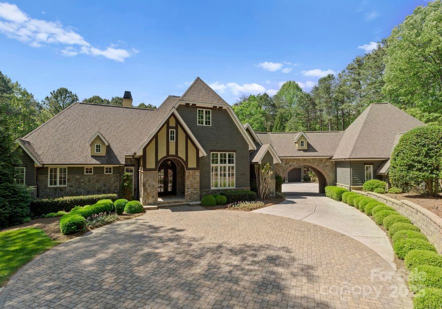 Nestled in the prestigious Sanctuary community, this custom estate combines timeless elegance with modern comfort on a 4.84 acre private, wooded lot. The open-concept main level showcases a gourmet kitchen, all high end appliances, vaulted living room with exposed beams, and seamless indoor-outdoor flow with walls of windows showcasing the serene natural setting. The full finished basement features a second living area, kitchenette, guest suites, and flexible space perfect for multigenerational living or extended stays. Enjoy your own private oasis with a heated saltwater pool, spa, waterfall, and multiple outdoor entertaining areas or enjoy movie nights in your dedicated home theater. A stately porte cochere adds a timeless architectural touch with 4-car garage. From high-end finishes throughout to a combination of privacy, luxury, and comfort all complete this one-of-a-kind retreat. A rare opportunity in one of the area’s most desirable neighborhoods. Refined Luxury at its best!